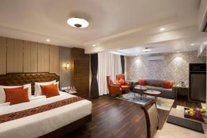 a hotel room with a bed and a living room at Hotel Suba Palace in Mumbai