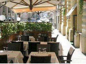 ein Restaurant mit weißen Tischen, Stühlen und einem Sonnenschirm in der Unterkunft Target Inn Rooms in Rom
