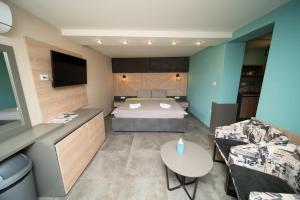 a bedroom with a bed and a couch and a table at Darija Apartments - City Square in Ohrid