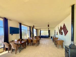 a dining room with tables and chairs and windows at Jabal Dana Hotel - the highest hotel in Jordan in Dana