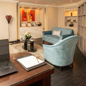 a office with a desk with a laptop and a chair at Corp Executive Hotel Doha Suites in Doha