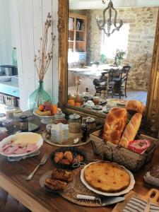 曼訥的住宿－Le Sens des Merveilles，餐桌上摆放着许多面包和糕点
