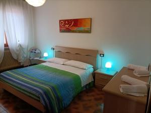 ロゾリーナにあるB&B ROSOLINAのベッドルーム1室(ベッド1台、テーブル2台、ランプ2つ付)