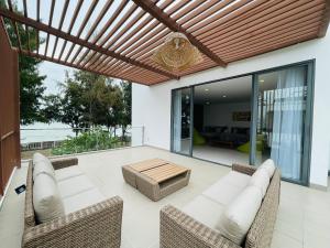 a patio with a wooden pergola and a table at Villa By Z-Mimosa 617 in Vung Tau