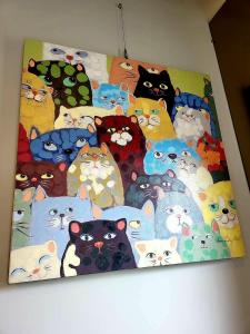 a painting of a group of cats on a wall at Tipsy Snail in Sanxing