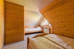 a bedroom with two beds in a wooden cabin at Domki Bystre in Baligród