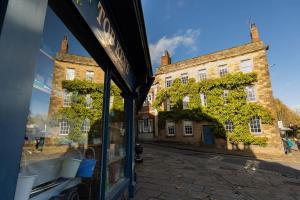 WirksworthにあるFryers Cottage - Beautiful 2 bedroom Town & Country Cottage on edge of Peak Districtの店窓の建物の反射