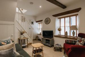 ein Wohnzimmer mit einem Sofa und einem TV in der Unterkunft Fryers Cottage - Beautiful 2 bedroom Town & Country Cottage on edge of Peak District in Wirksworth