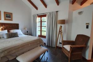 a bedroom with a bed and a chair and a window at Casa privada amplia y tranquila, rodeada de naturaleza. in Lago Puelo +11 photos