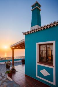 a blue building with a lighthouse on the beach at Casa marroquina in Las Indias