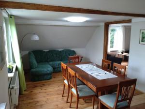 a dining room with a table and a couch at FeWo Wolfseiche in Jänkendorf