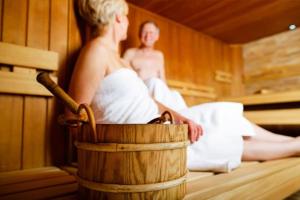 a man and a woman sitting in a sauna at Innsletta holiday home in Harstad