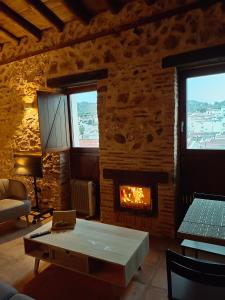ein Wohnzimmer mit einem Tisch und einem Kamin in der Unterkunft Balcón de la Moreria con alberca in Constantina