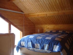 Grand Valtin : chalet écolo 4 étoiles 14 personnes في Ban-sur-Meurthe-Clefcy: سرير في كابينة ذات سقف خشبي