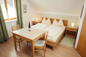 a bedroom with a bed and a table with a bottle of wine at Weingut Jakob`s Ruhezeit in Mautern
