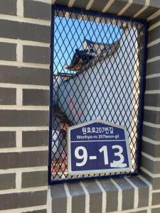 una señal en una ventana de un edificio de ladrillo en Gyeongju Sugi's Guesthouse, en Gyeongju
