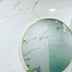 a mirror on a wall in a bathroom at Gyeongju Sugi's Guesthouse in Gyeongju
