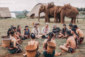a group of people sitting on the ground with elephants at La Villa Hortensia-Mondulkiri in Phumĭ Pu Pal