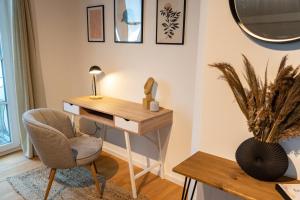 a desk and a chair in a room at Hejm Apart - Design Maisonette-Ferienwohnung "Zugspitze" in Mering