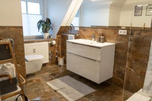 a bathroom with a sink and a toilet at Hejm Apart - Design Maisonette-Ferienwohnung "Zugspitze" in Mering