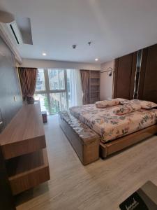 a bedroom with a bed and a large window at Apartemen Grand Jati Junction Medan 3 Kamar in Medan