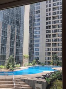 a view of a swimming pool with tall buildings at Apartemen Grand Jati Junction Medan 3 Kamar in Medan