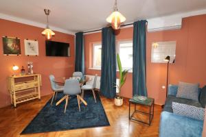 salon z pomarańczowymi ścianami oraz stołem i krzesłami w obiekcie Studio City w Lublanie