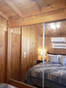 a bedroom with a bed in a wooden cabin at The Couple's Cabin in Wynola 2 NIGHT MINIMUM in Julian