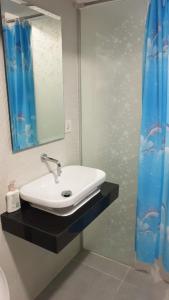 uma casa de banho com um lavatório e um espelho em Apartemen Grand Jati Junction Medan 3 Kamar em Medan