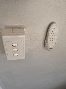 a white outlet on a wall with a remote control at Between the Beach Flags, Luxury Family Hideaway - Recent Reno in The Entrance