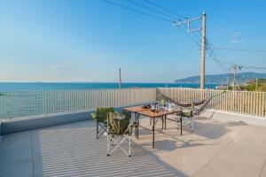 a patio with a table and chairs on a balcony at Ryū shi ma Ocean View Villa in Kyonan