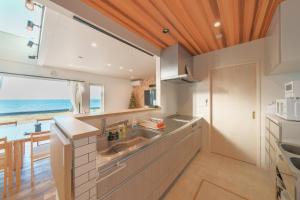 a kitchen with a sink and a view of the ocean at Ryū shi ma Ocean View Villa in Kyonan