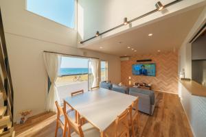a dining room with a table and a view of the ocean at Ryū shi ma Ocean View Villa in Kyonan