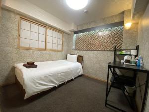 a bedroom with a white bed and a desk at Allcomein Hotel Akihabara in Tokyo