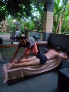 a woman is giving a man a massage at Apollo Hostel in Lovina