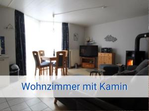 a living room with a table and chairs and a couch at Böltser Hus Ferienwohnungen mit Strandkorb und Kamin 10 Gehminuten zum kurtaxefreien Sandstrand in Neukirchen