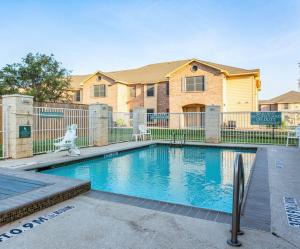 a swimming pool in front of a house at Red Roof Inn & Suites Midland in Midland