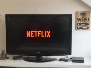 einen Fernsehbildschirm mit den Worten Netflix in der Unterkunft F3 centre d hericourt Fibre et Netfix in Héricourt