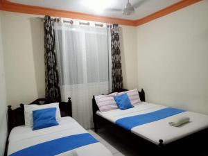two beds in a room with blue and white at Mtwapa luxury Gold Star 3br in Kilifi