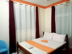 a small bedroom with a bed with red curtains at Mtwapa luxury Gold Star 3br in Kilifi