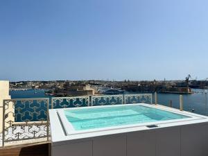 a swimming pool on the balcony of a building at Iniala Harbour House in Valletta