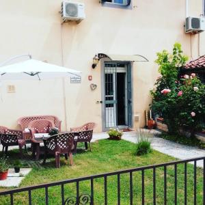 a patio with a table and chairs and an umbrella at Relais Le Ortensie in Pisa
