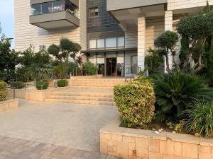 a building with stairs and plants in front of it at סוויטה מדהימה במרכז הארץ-amazing suite in the center of the country in Beʼer Ya‘aqov