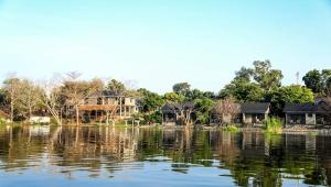 a view of a lake with houses in the background at Gipir and Labongo Safari Lodge Ltd in Pakwach East