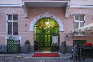 a front door of a pink building with a green door at St.Olav Hotel in Tallinn