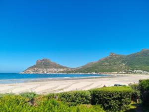 a sandy beach with mountains in the background at Beautiful apartment across from the beach in Cape Town