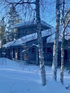 a log cabin in the snow with trees at Katasijan Villa in Salla