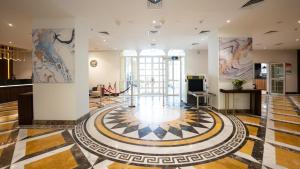 a lobby with a checkerboard floor in a building at Somerset Al Mansoura Doha in Doha