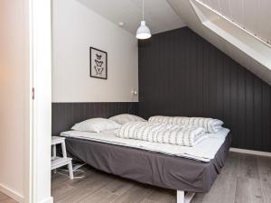 a bed in a room with a black wall at Holiday home Hovborg VIII in Hovborg