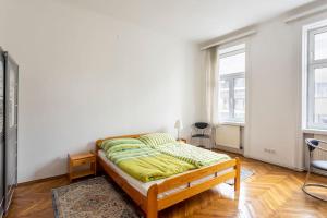 a bedroom with a bed and two windows at vintage living in the heart of Vienna. in Vienna